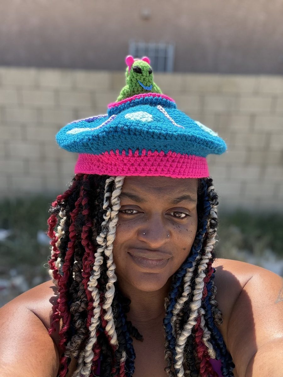 Renee, owner of Sa\/age Th!ngz, wearing one of her crochet mushroom hats